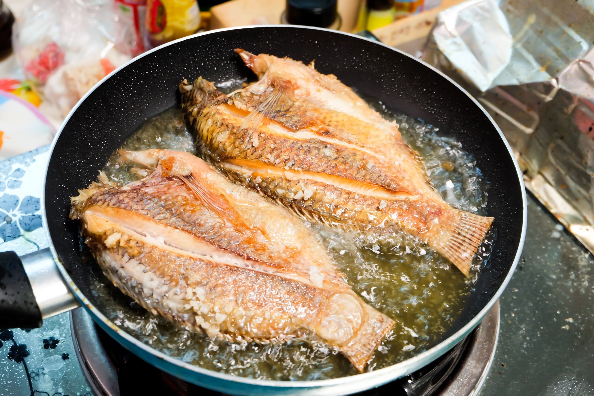 ExploreGear.com: Crispy golden panfish frying in a skillet, showcasing a delicious and simple way to prepare a fresh catch for a family meal.