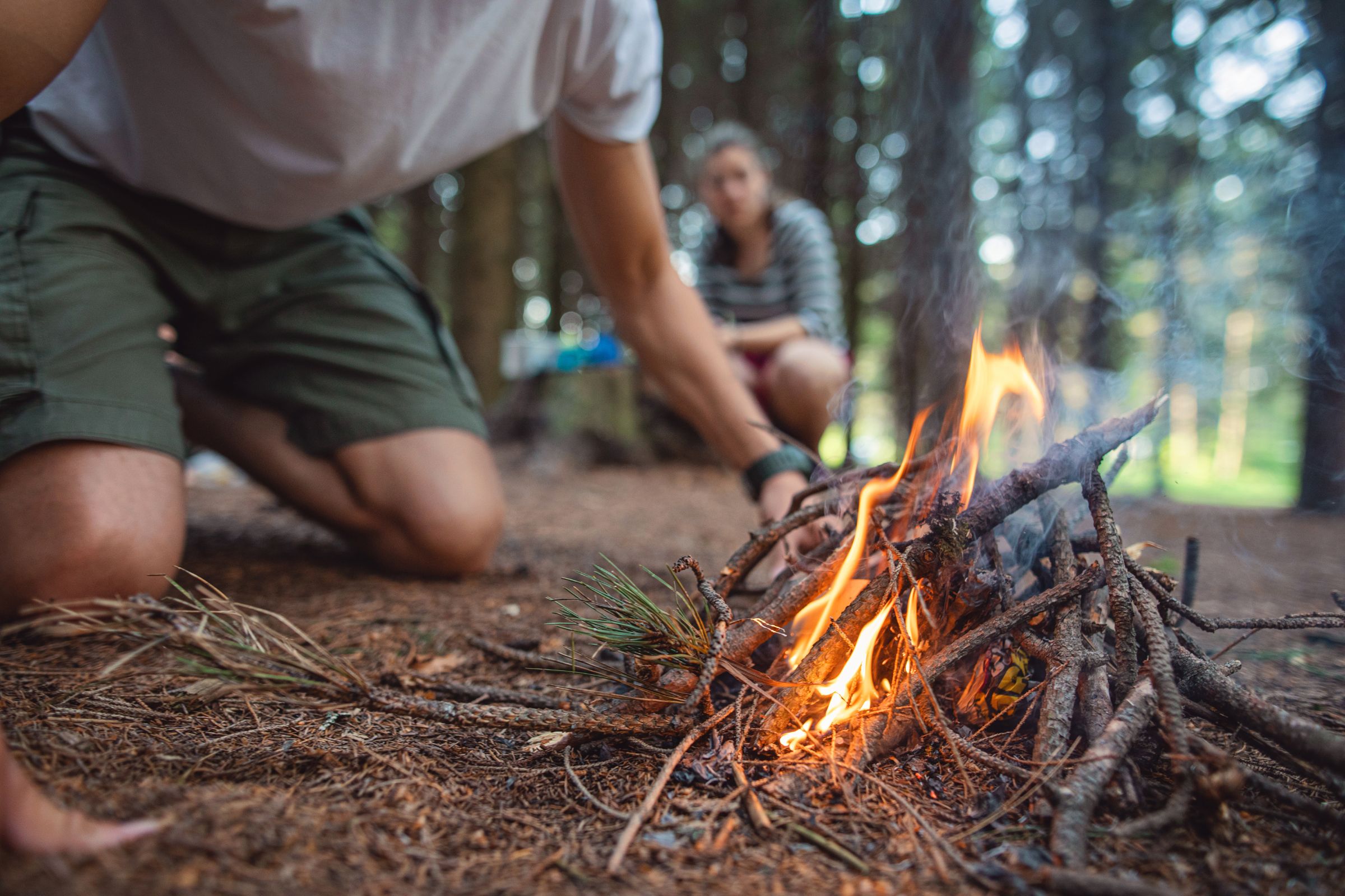 ExploreGear.com | Starting a campfire outdoors, essential bushcraft survival skill demonstration.